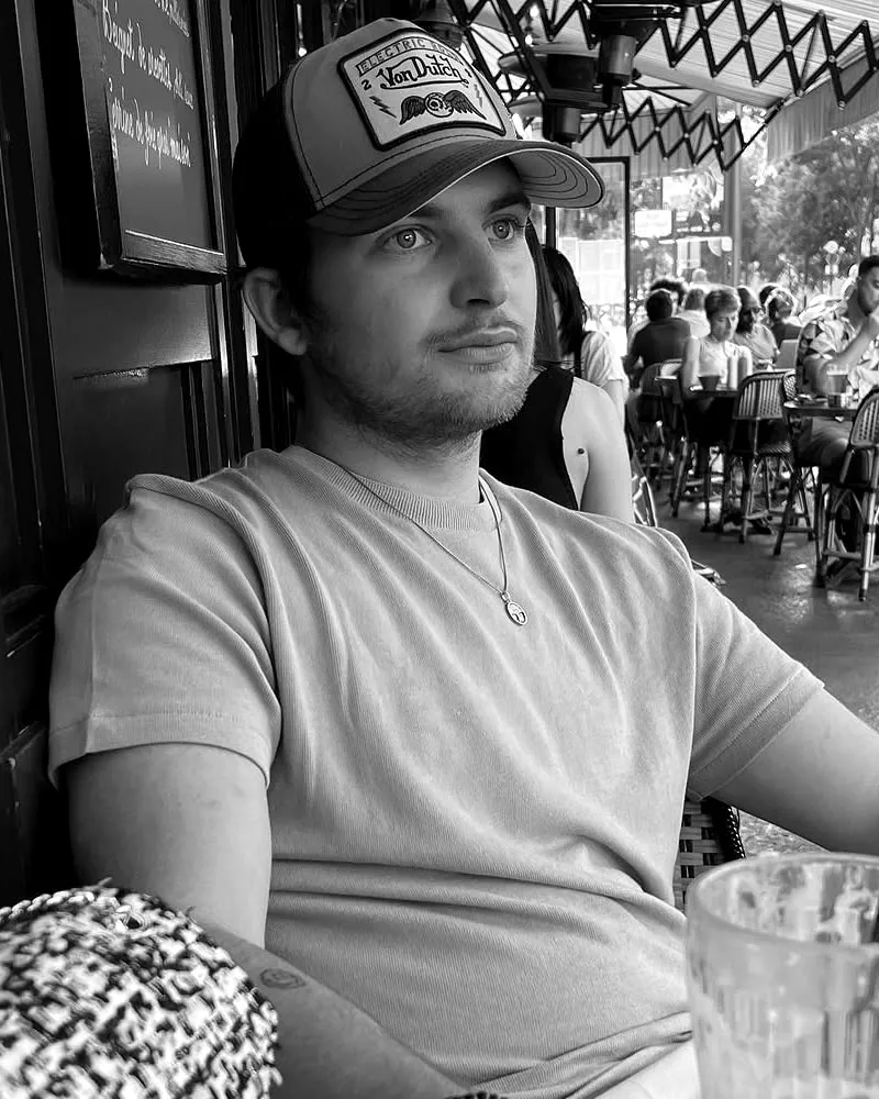 Théo, fondateur de NEUV, en terrasse de café. Portrait en noir et blanc.